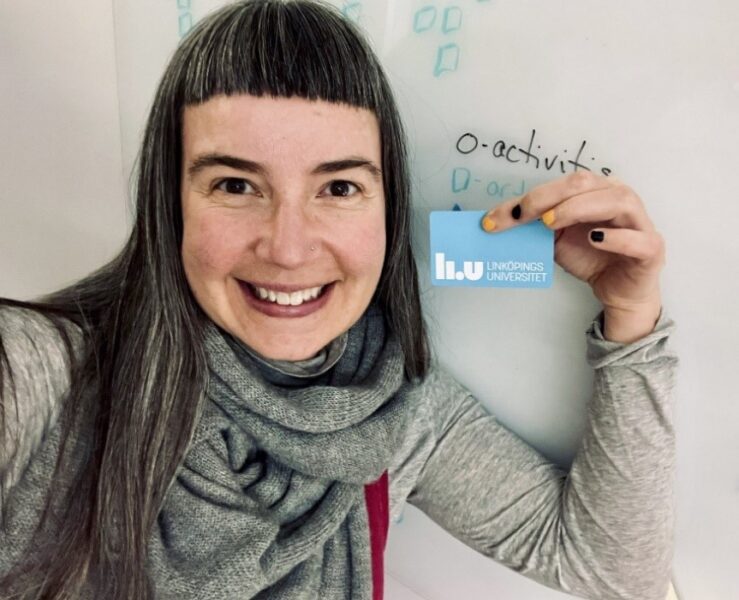 Miriah Meyer in a closeup holding her blue LiU card