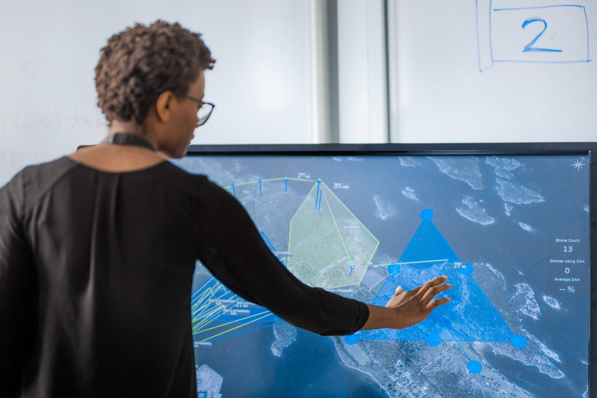 A person pointing at a screen.