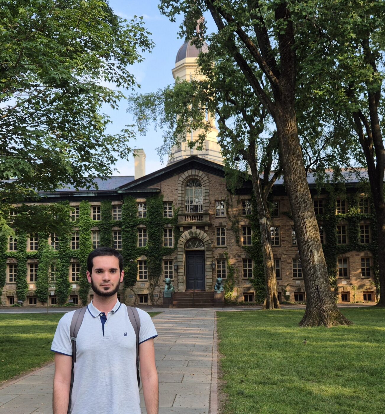 A man standing in front of a yellow brick building.
