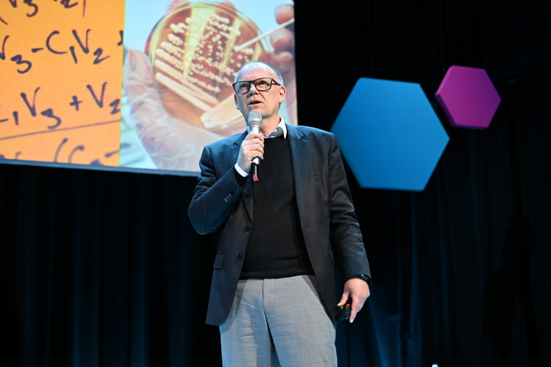 Man talking on stage with microphone