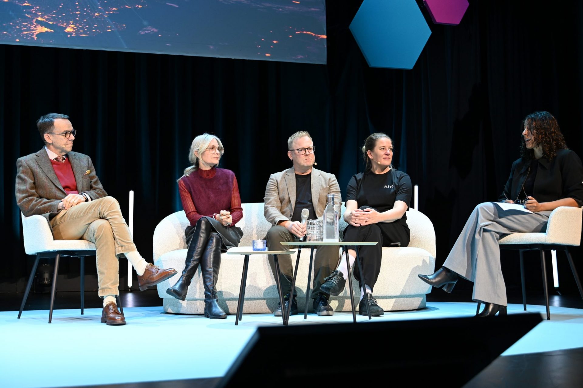 Two men and three women sitting in panel discusion on stage