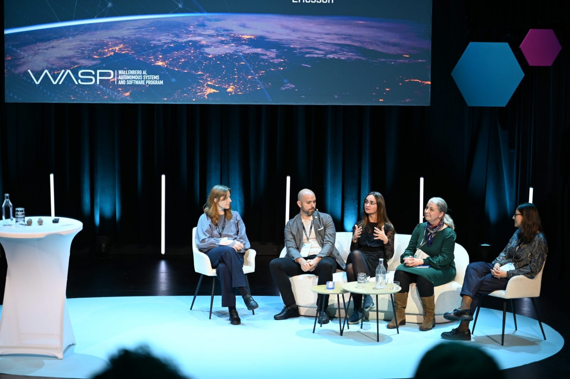 Panel discussion on stage with four women and one man.