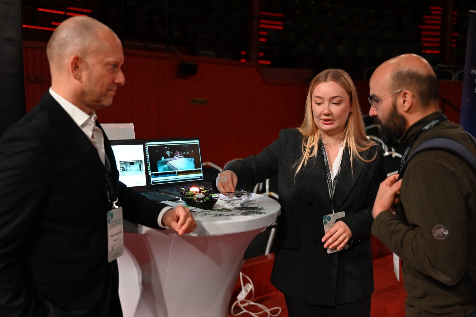 two men and one woman talking at exhibition