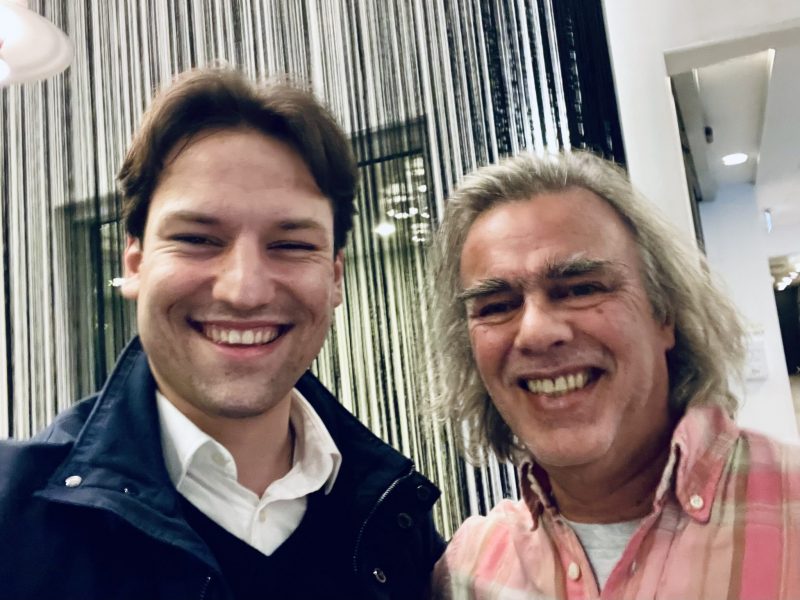 Two men smiling into the camera